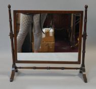 A 19th century mahogany swing toilet mirror with original plate in ring turned frame on swept