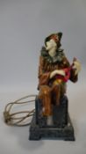 An Art Deco style resin court jester playing the mandolin light, he is sitting on a stepped marble