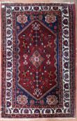 A Persian Abadeh rug with floral pole medallion on a madder field within spandrels with gul motifs