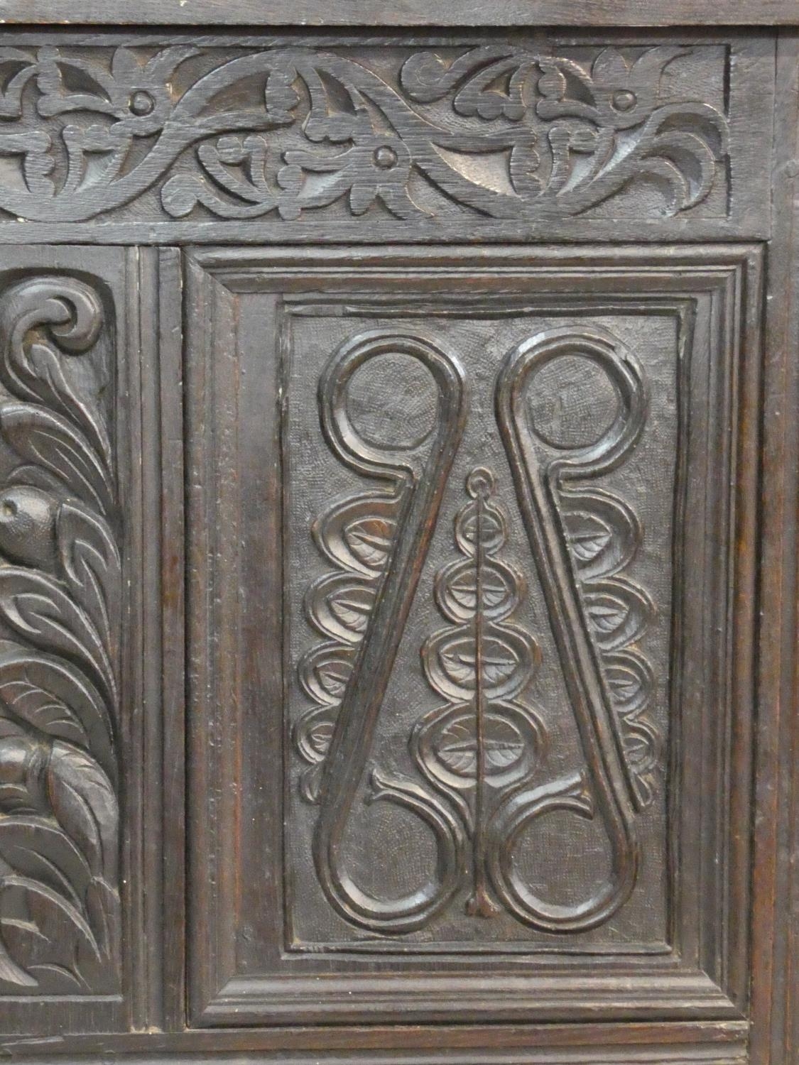 An antique country oak coffer with hinged lid above floral carved panels on block feet. H.75 L.136 - Image 6 of 9