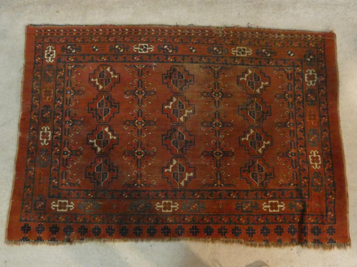 A Shirvan rug with repeating gul motifs across the madder ground contained by multiple stylised