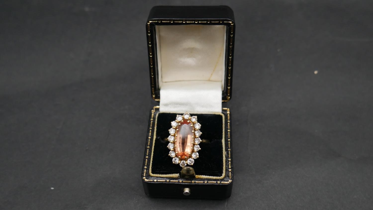 A vintage 18ct yellow gold topaz and diamond oval cluster dress ring. Set with an oval mixed cut