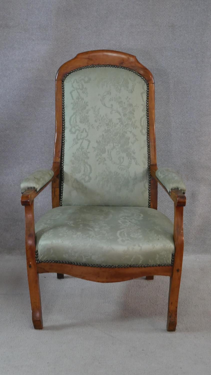 A 19th century French provincial fruitwood armchair in floral damask upholstery. H.109cm