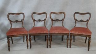 A set of four mid 19th century rosewood dining chairs with shaped backs above drop in seats on