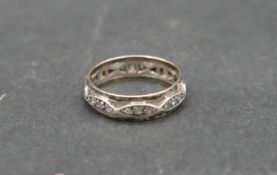 An antique white metal and yellow metal eternity band set with hand cut white stones. With shaped