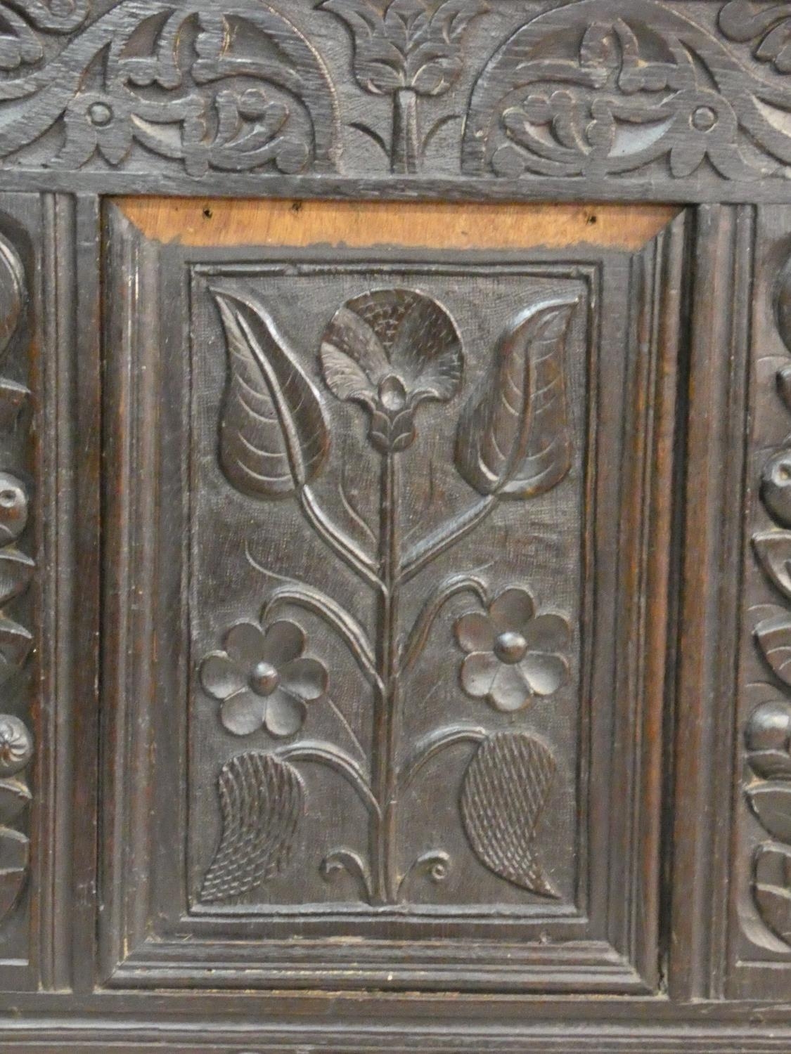 An antique country oak coffer with hinged lid above floral carved panels on block feet. H.75 L.136 - Image 5 of 9