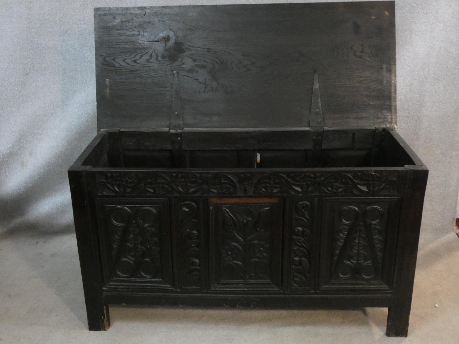 An antique country oak coffer with hinged lid above floral carved panels on block feet. H.75 L.136 - Image 2 of 9