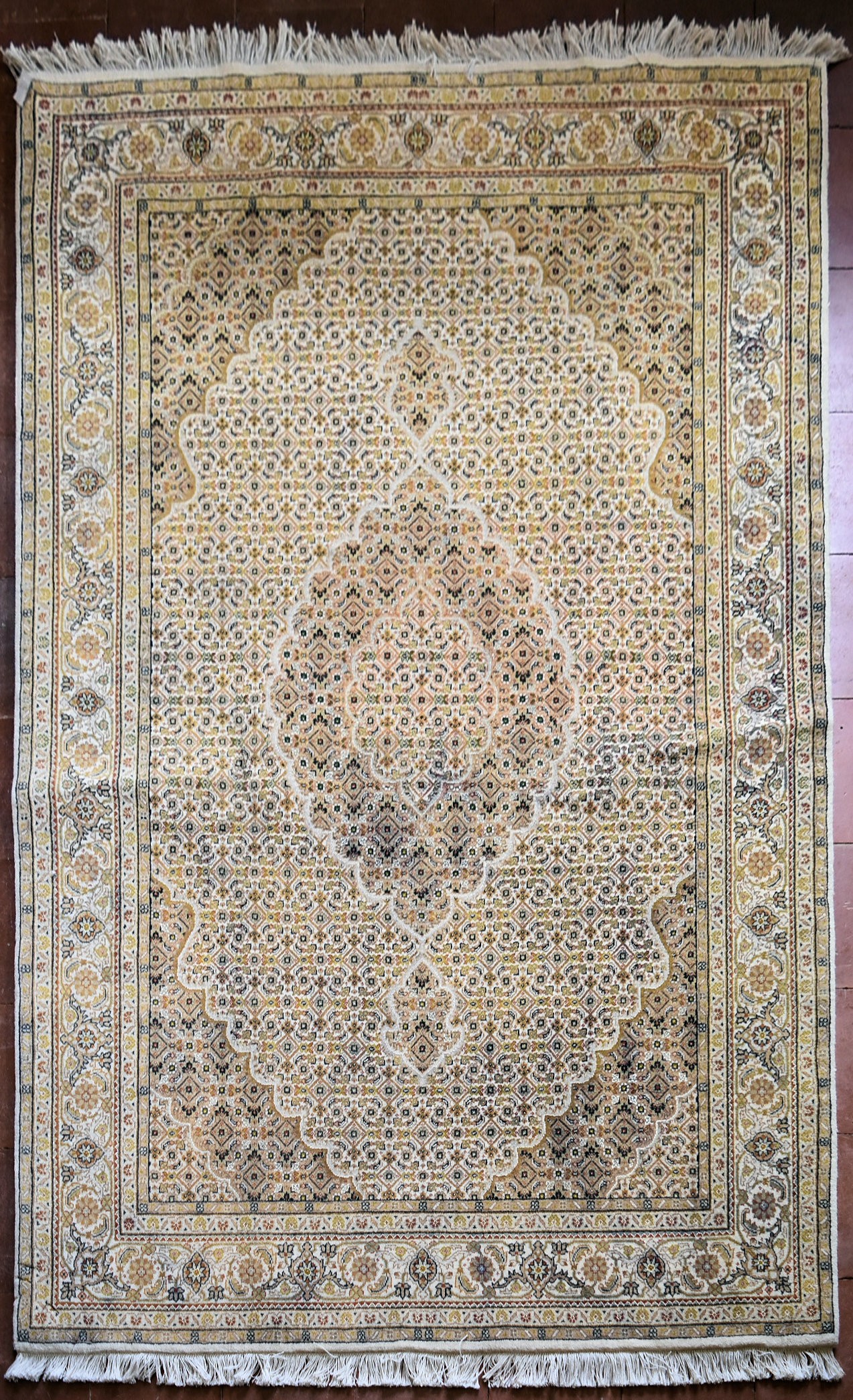 A silk & wool Tabriz style carpet with central medallion and repeating floral design across the fawn