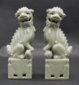 A pair of Celadon glazed Qing dynasty Chinese porcelain Fo dogs seated on square plinths. H.25cm