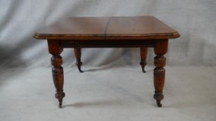 A late 19th century mahogany extending dining table with extra leaf on turned tapering supports. H.