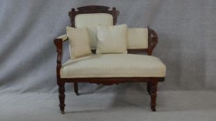 A late 19th century carved walnut small chaise in polka dot upholstery raised on turned tapering