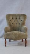 A contemporary Victorian style armchair in deep buttoned upholstery on turned shaped supports. H.