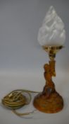 A moulded amber glass lamp base, young girl holding a flaming torch aloft. H.43cm