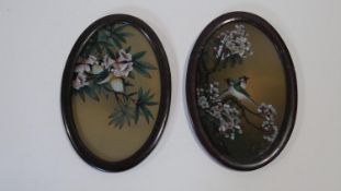 Two oval framed and glazed Japanese acrylic on glass paintings of birds in blossom trees. H.30 W.