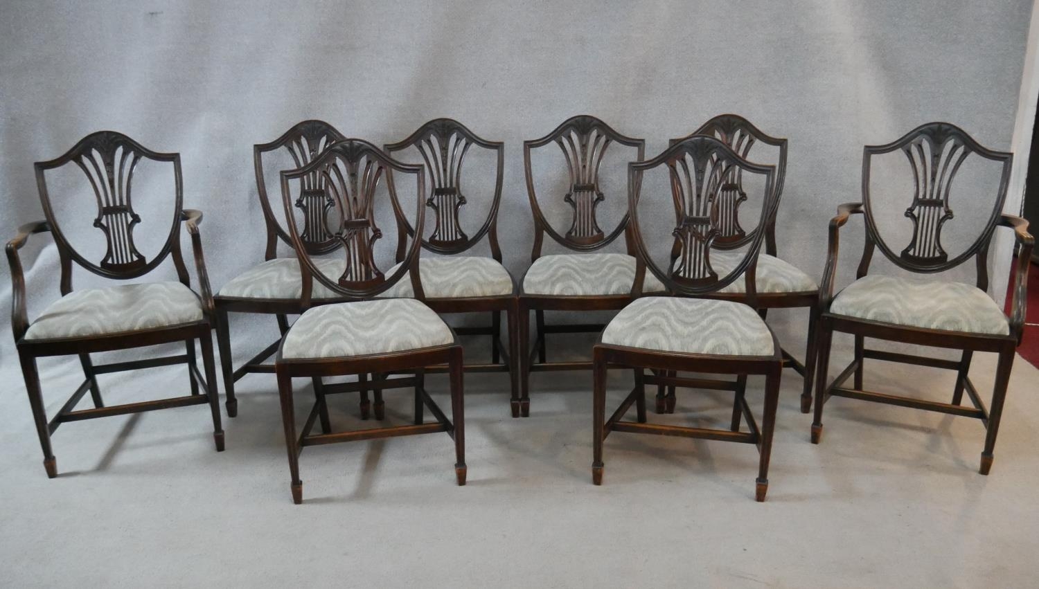 A set of eight Hepplewhite style mahogany shield back dining chairs with drop in seats on square