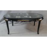 A Chinese black lacquered dining table with applied figural decoration and hand painted detail on