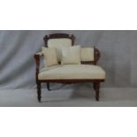 A late 19th century carved walnut small chaise in polka dot upholstery raised on turned tapering