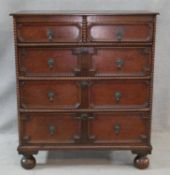 A mid century Jacobean style oak chest of two above three lozenge panelled drawers on bun feet. H.