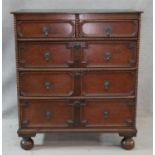 A mid century Jacobean style oak chest of two above three lozenge panelled drawers on bun feet. H.