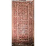 An antique Persian Malayer carpet with repeating diamond and foliate design across the central field