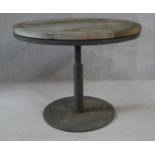 A weathered teak garden table on metal pedestal base. H.73 D.91.5cm