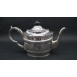 A Georgian silver tea pot with engraved laurel leaf decoration and Greek key design circular