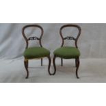 A pair of Victorian carved mahogany balloon back dining chairs on cabriole supports. H.88cm (damaged