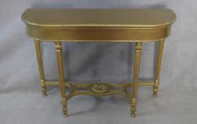 A 19th century style gilt console table on tapering fluted supports united by scrolling under
