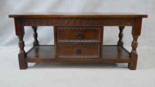 A mid century Jacobean style oak coffee table on baluster turned supports united by under tier