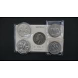 Five silver coins. Including a 1935 silver crown of George V in a presentation wallet, two 1935