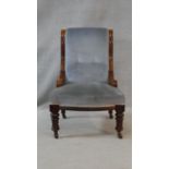 A 19th century mahogany framed nursing chair in buttoned upholstery on turned tapering supports. H.
