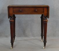 A mid 19th century mahogany writing table with inset leather top and drop flaps with frieze drawer