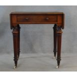 A mid 19th century mahogany writing table with inset leather top and drop flaps with frieze drawer