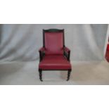 A Victorian carved frame armchair in faux leather upholstery on turned tapering supports. H.98cm