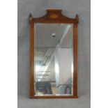 An Adam style yew framed wall mirror with inlaid patera and urn finials to the cresting and bevelled