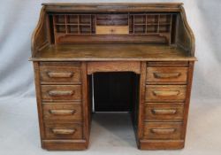 A 19th century oak roll top desk with S shaped tambour front enclosing interior fitted with numerous