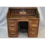A 19th century oak roll top desk with S shaped tambour front enclosing interior fitted with numerous