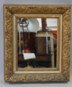 A 19th century gilt wood and gesso wall mirror in floral decorated frame. H.59 W.51cm