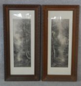 A pair of late 19th century carved oak framed and glazed greyscale prints of woodland river scenes