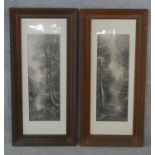 A pair of late 19th century carved oak framed and glazed greyscale prints of woodland river scenes