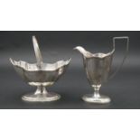A Victorian silver handled sugar bowl and cream jug with linear detailing around the scalloped rim