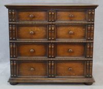 A mid century Jacobean style oak chest of four long graduating drawers on bun feet. H.102 W.112 D.