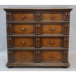 A mid century Jacobean style oak chest of four long graduating drawers on bun feet. H.102 W.112 D.