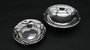 A white metal and Continental silver bowl. One with fluted edge and sitting on three ball feet.