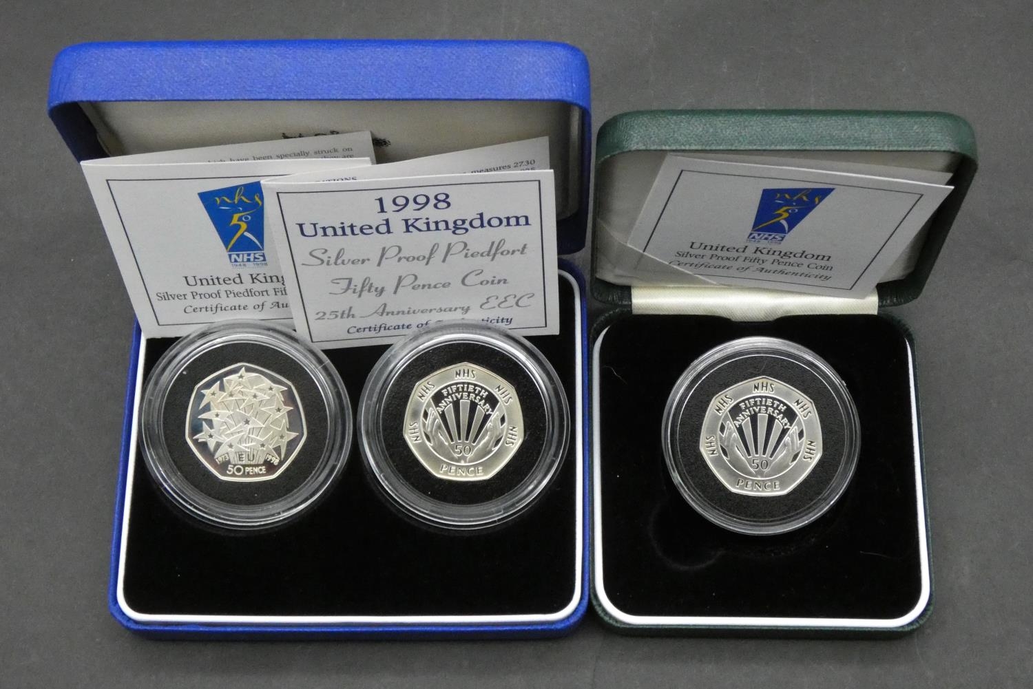 Three Royal Mint silver proof 50p coins. Including a cased set of two silver proof piedfort 50 pence