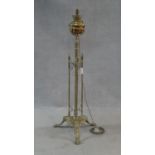 A Victorian brass standard oil lamp on reeded central column and tripod foliate swept supports,