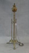 A Victorian brass standard oil lamp on reeded central column and tripod foliate swept supports,