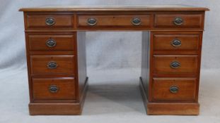 A C.1900 walnut Georgian style pedestal desk with inset tooled leather top above an arrangement of