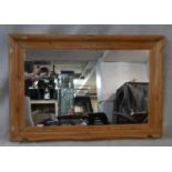 A wall mirror in carved and moulded pitch pine frame. H.86.5 W.126.5cm
