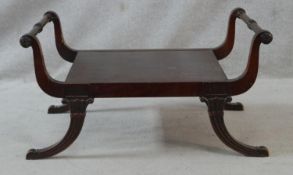 A Regency style mahogany window seat on swept reeded supports. H.43 L.82 W.52cm